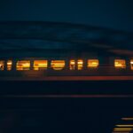 A moving train at night captured with motion blur, illuminating the cityscape of Hamburg.