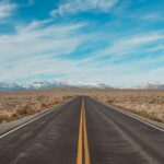 gray concrete road under blue sky during daytime
